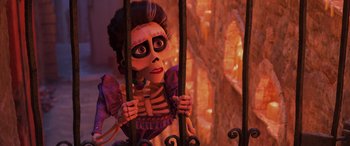 Movie still from “Coco” (2017), directed by Adrian Molina – A woman in a purple dress holding onto a metal fence; Medium shot, Over the shoulder angle