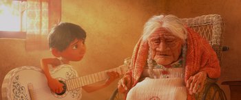 Movie still from “Coco” (2017), directed by Adrian Molina – An old woman sitting in a chair next to a young boy; Medium shot, Over the shoulder angle
