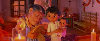 Movie still from “Coco” (2017), directed by Adrian Molina – An old man and a young boy holding a baby; Medium shot, Over the shoulder angle