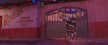 Movie still from “Coco” (2017), directed by Adrian Molina – A group of people standing in front of an open garage door; Wide shot, Low angle