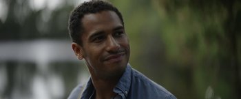 Movie still from “Color Out of Space” (2019), directed by Richard Stanley – A person wearing a blue shirt smiling; Close Up shot, Over the shoulder angle