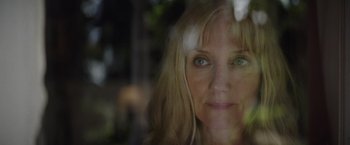 Movie still from “Color Out of Space” (2019), directed by Richard Stanley – A woman's face in front of a window; Close Up shot, Low angle