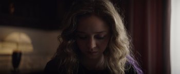 Movie still from “Color Out of Space” (2019), directed by Richard Stanley – A woman with long blonde curly hair looking down at her face; Close Up shot, Low angle