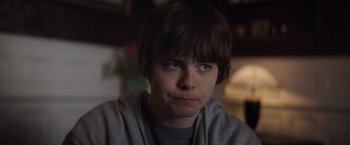 Movie still from “Color Out of Space” (2019), directed by Richard Stanley – A young man is looking into the camera; Close Up shot, Over the shoulder angle
