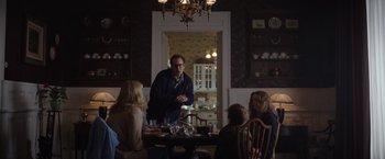 Movie still from “Color Out of Space” (2019), directed by Richard Stanley – A group of people sitting around a table with food on top of it; Medium shot, Over the shoulder angle
