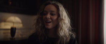 Movie still from “Color Out of Space” (2019), directed by Richard Stanley – A woman with long blonde hair is smiling; Close Up shot, Over the shoulder angle