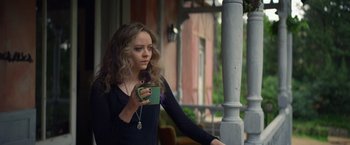 Movie still from “Color Out of Space” (2019), directed by Richard Stanley – A woman is holding a cup of coffee outside; Medium shot, Over the shoulder angle