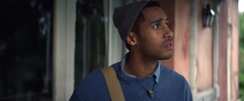 Movie still from “Color Out of Space” (2019), directed by Richard Stanley – A young man wearing a hat looking up at the sky; Close Up shot, Over the shoulder angle