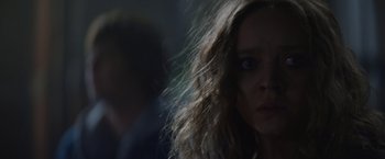 Movie still from “Color Out of Space” (2019), directed by Richard Stanley – A woman with long brown hair stares at the camera; Close Up shot, Over the shoulder angle
