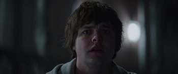 Movie still from “Color Out of Space” (2019), directed by Richard Stanley – A young man with short brown hair stares into the camera; Close Up shot, Low angle