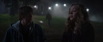 Movie still from “Color Out of Space” (2019), directed by Richard Stanley – A couple of people standing next to each other on a field at night; Medium shot, Over the shoulder angle