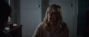 Movie still from “Color Out of Space” (2019), directed by Richard Stanley – A woman sitting in front of a door looking up; Close Up shot, Over the shoulder angle