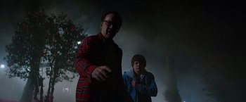 Movie still from “Color Out of Space” (2019), directed by Richard Stanley – Two men standing next to each other in the dark; Medium shot, Over the shoulder angle
