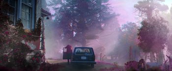 Movie still from “Color Out of Space” (2019), directed by Richard Stanley – A person standing on the side of a road near a car; Wide shot, Low angle