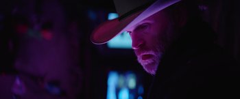 Movie still from “Color Out of Space” (2019), directed by Richard Stanley – A man with a beard wearing a cowboy hat; Close Up shot, Low angle