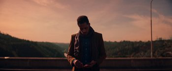 Movie still from “Color Out of Space” (2019), directed by Richard Stanley – A man in a brown jacket is looking at his cell phone; Medium shot, Low angle