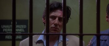 Movie still from “The Usual Suspects” (1995), directed by Bryan Singer – A person behind a fence; Close Up shot, Low angle