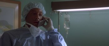 Movie still from “The Usual Suspects” (1995), directed by Bryan Singer – A man in a hospital gown talking on a cell phone; Close Up shot, Low angle