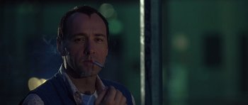 Movie still from “The Usual Suspects” (1995), directed by Bryan Singer – A person smoking a cigarette; Close Up shot, Low angle