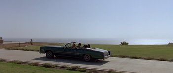 Movie still from “The Usual Suspects” (1995), directed by Bryan Singer – A group of people riding in the back of a green car; Extreme Wide shot, High angle