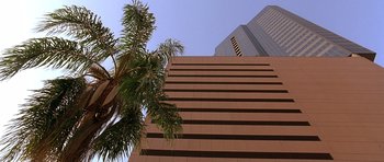 Movie still from “The Usual Suspects” (1995), directed by Bryan Singer – A palm tree in front of a tall building; Extreme Wide shot, Low angle