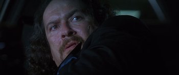 Movie still from “The Usual Suspects” (1995), directed by Bryan Singer – A person with a beard and mustache; Close Up shot, Low angle