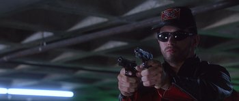 Movie still from “The Usual Suspects” (1995), directed by Bryan Singer – A man holding two pistols while wearing a hat; Close Up shot, Low angle