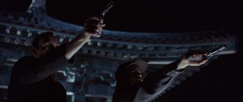 Movie still from “The Usual Suspects” (1995), directed by Bryan Singer – A man holding a gun up to the sky; Close Up shot, Low angle