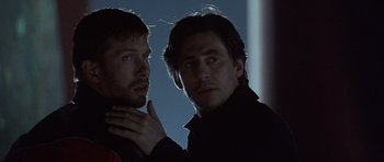 Movie still from “The Usual Suspects” (1995), directed by Bryan Singer – A couple of men standing next to each other; Close Up shot, Low angle