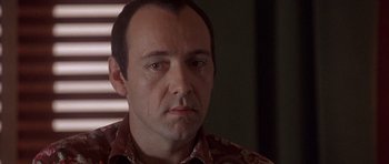 Movie still from “The Usual Suspects” (1995), directed by Bryan Singer – A person wearing a floral shirt; Close Up shot, Over the shoulder angle