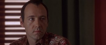 Movie still from “The Usual Suspects” (1995), directed by Bryan Singer – A person wearing a red shirt; Close Up shot, Over the shoulder angle