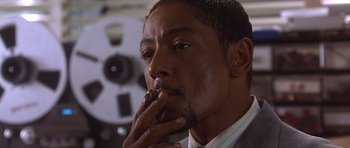 Movie still from “The Usual Suspects” (1995), directed by Bryan Singer – A person smoking a cigarette; Close Up shot, Low angle