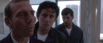 Movie still from “The Usual Suspects” (1995), directed by Bryan Singer – A group of men standing next to each other in front of a window; Close Up shot, Low angle