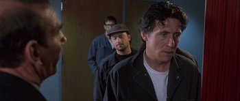 Movie still from “The Usual Suspects” (1995), directed by Bryan Singer – A group of men standing next to each other in a room; Close Up shot, Over the shoulder angle