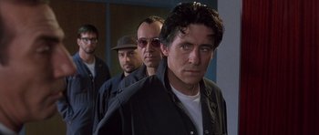 Movie still from “The Usual Suspects” (1995), directed by Bryan Singer – A group of men standing next to each other in a room; Close Up shot, Low angle