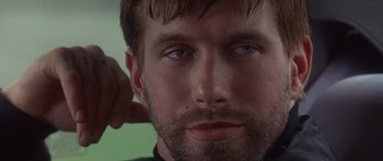 Movie still from “The Usual Suspects” (1995), directed by Bryan Singer – A man with a beard and blue eyes; Close Up shot, Over the shoulder angle