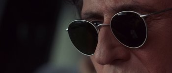 Movie still from “The Usual Suspects” (1995), directed by Bryan Singer – A person wearing a pair of sunglasses; Extreme Close Up shot, Low angle