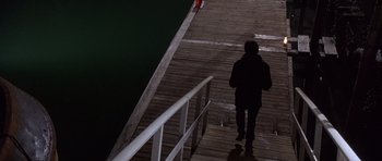 Movie still from “The Usual Suspects” (1995), directed by Bryan Singer – A man walking down a wooden pier at night; Wide shot, High angle