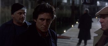 Movie still from “The Usual Suspects” (1995), directed by Bryan Singer – A man in a black jacket and red neck tie; Close Up shot, Low angle