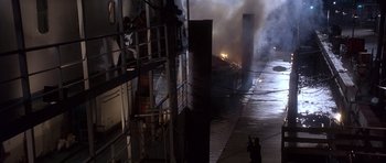 Movie still from “The Usual Suspects” (1995), directed by Bryan Singer – A man taking a picture of a fire in a building; Extreme Wide shot, High angle