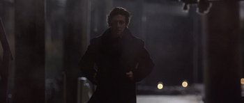Movie still from “The Usual Suspects” (1995), directed by Bryan Singer – A man in a black coat walking on a street; Medium shot, Low angle