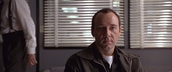 Movie still from “The Usual Suspects” (1995), directed by Bryan Singer – A person wearing a jacket; Close Up shot, Over the shoulder angle