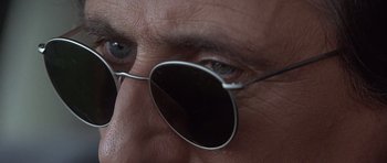 Movie still from “The Usual Suspects” (1995), directed by Bryan Singer – A person wearing a pair of glasses; Extreme Close Up shot, Low angle