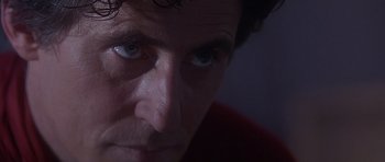 Movie still from “The Usual Suspects” (1995), directed by Bryan Singer – A man's face in a dark room; Extreme Close Up shot, Over the shoulder angle