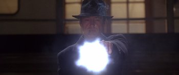 Movie still from “The Usual Suspects” (1995), directed by Bryan Singer – A man in a hat is holding a flashlight; Close Up shot, Low angle