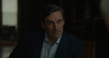 Movie still from “Confess, Fletch” (2022), directed by Greg Mottola – A person wearing a suit and tie; Close Up shot, Over the shoulder angle