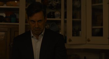 Movie still from “Confess, Fletch” (2022), directed by Greg Mottola – A person wearing a suit in a room; Close Up shot, Over the shoulder angle
