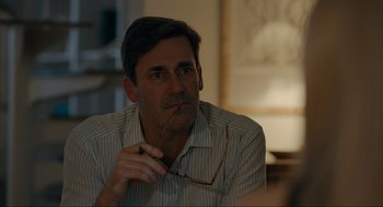 Movie still from “Confess, Fletch” (2022), directed by Greg Mottola – A person wearing glasses; Close Up shot, Over the shoulder angle