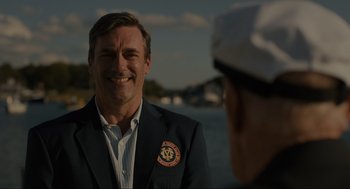 Movie still from “Confess, Fletch” (2022), directed by Greg Mottola – A man in a suit and a sailor's hat; Close Up shot, Over the shoulder angle