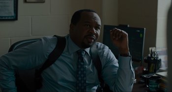 Movie still from “Confess, Fletch” (2022), directed by Greg Mottola – A man in a blue dress shirt and a tie; Close Up shot, Over the shoulder angle